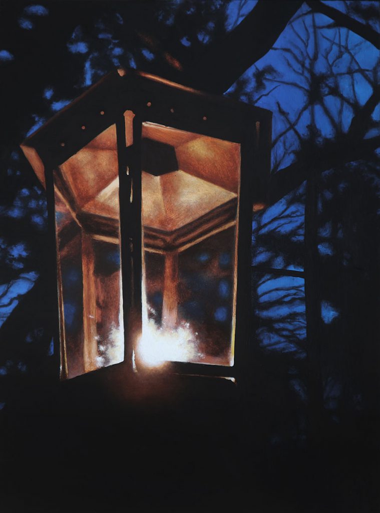 A candle lantern on a tree at night